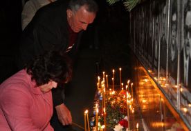 A victim relations puts candles near the Memorial to Heroes of Chernobyl