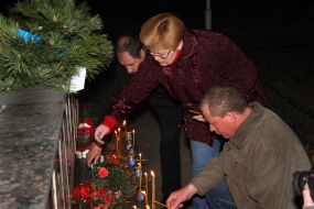 A victim relations puts candles near the Memorial to Heroes of Chernobyl
