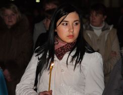 Дівчина тримає палаючу свічку