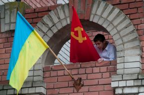 A boy places a Soviet flag