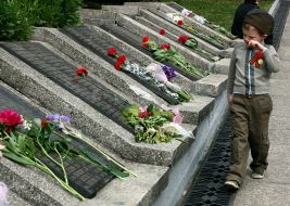 A boy passes near a memorial to the lost warriors of Great Patriotic war