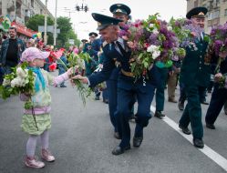 A girl give flowers to the Great Patriotic war veteran