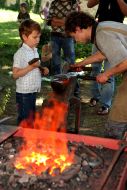 A boy helps a blacksmith
