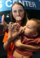 Мать с соской во рту, кормит своего ребенка