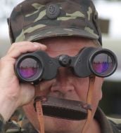 An officer looks in binoculars
