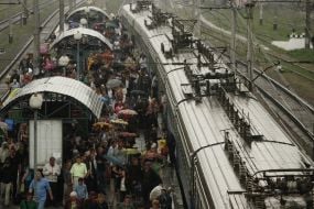 Passengers stand on a platform