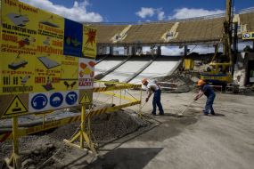 Workers wipe off the buildings offcuts