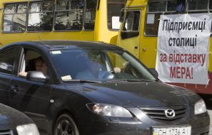 Автомобили проезжают возле маршрутных такси