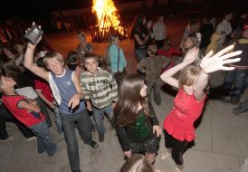 Children dance near a fire