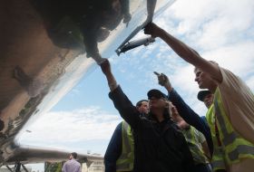 The workers of technical service examine an airplane