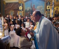 Мальчик принимает первое причастие