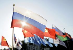 A sun lights through the Russian flag