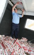 A customs official takes out the blocks of cigarettes
