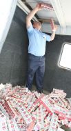 A customs official takes out the blocks of cigarettes