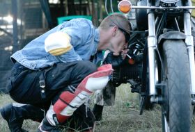 Bayker kindles a cigarette from the engine of motor cycle