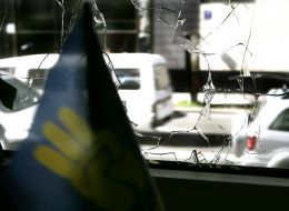 Флаг с эмблемой партии ”Свобода” в разбитом окне