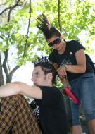 A girl-pank does a hair-do (mohawk) to the friend