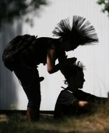 A girl-pank does a hair-do (mohawk) to the friend