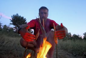 Participant of the expedition cooks fish