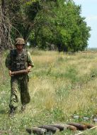 Военнослужащий несет в руках боевой снаряд