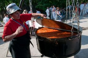 Повар варит борщ в казане