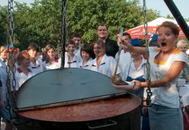 Девушка наливает борщ в тарелку