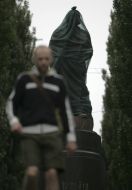 Passerby near a monument to Lenin