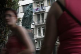 Passersby near a monument to Lenin