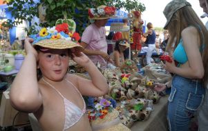 A girl measures a straw hat