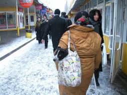 A woman carries a dog in a bag