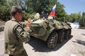 A serviceman controls фrmoured personnel carries column motion