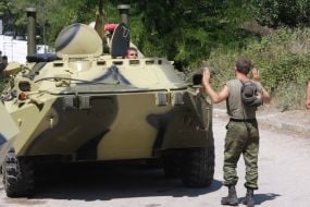 A serviceman controls фrmoured personnel carries column motion