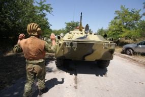 A serviceman controls фrmoured personnel carries column motion
