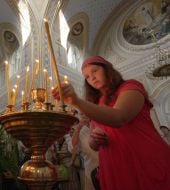 Девушка ставит свечу