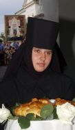 A nun holds round loaf