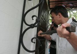 A man breaks out the doors of his own house