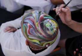 An artist covers with drawing a model’s head