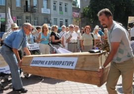 Участники акции протеста несут гроб