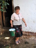 A woman carries a bucket with fresh milk