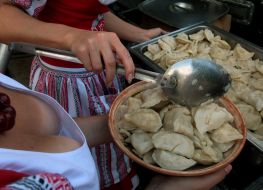 Девушка насыпает вареники в миску