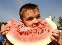 Мальчик ест арбуз