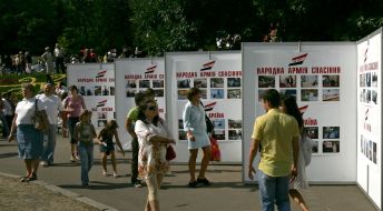 Прохожие идут возле стендов