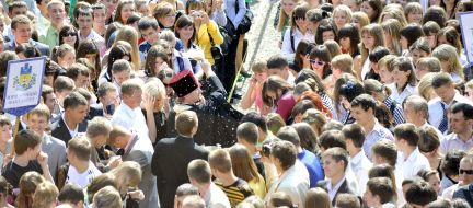 A priest splashes sainted water of students
