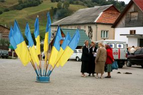 Elderly women stand near the flags of Ukraine
