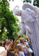 Man on stilts in the angel’s suit