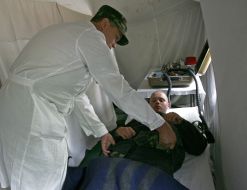 A military doctor render aid to the ”sick refugee”