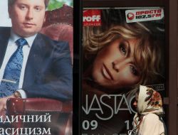 An elderly woman goes near a publicity banner