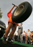 A man heaves a motor-car wheel