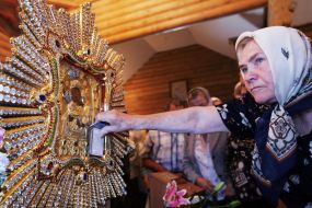 A believer puts icons to Pochaev Icon of the Mother of God