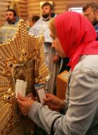 A believer puts icons to Pochaev Icon of the Mother of God